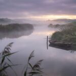 Ruhiges Gewässer im Morgennebel als Symbol für Geduld und Ausdauer