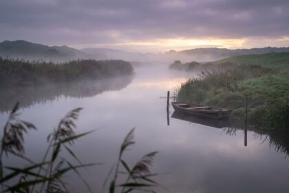 Ruhiges Gewässer im Morgennebel als Symbol für Geduld und Ausdauer